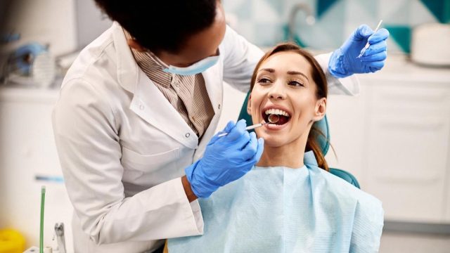 Orthodontist examining a smiling patient during a bite assessment in a UAE clinic