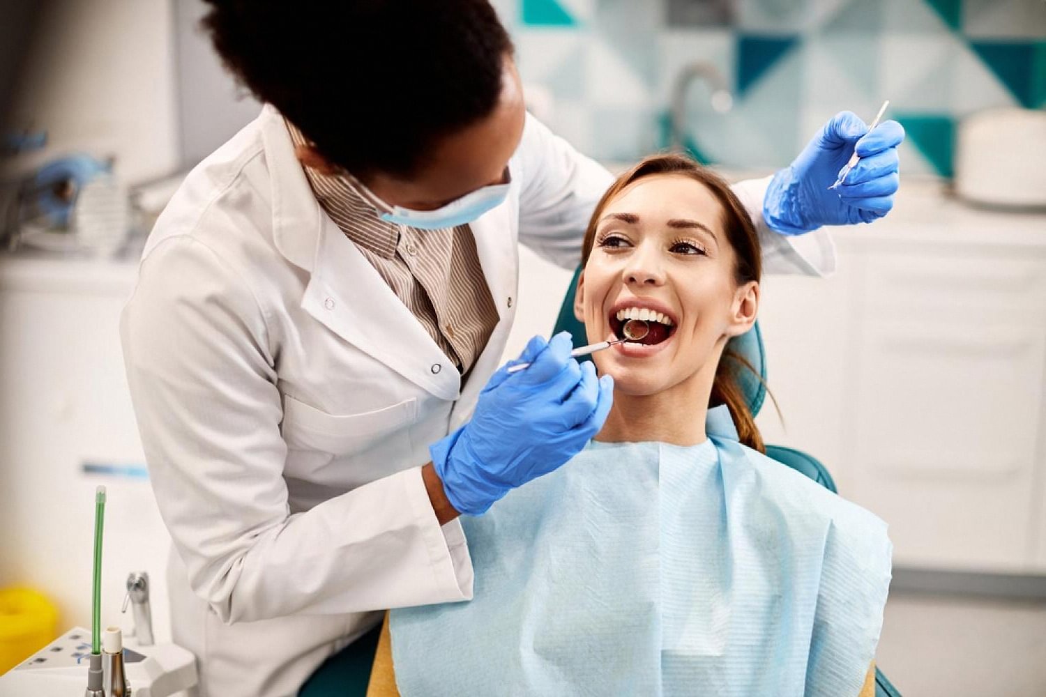 Orthodontist examining a smiling patient during a bite assessment in a UAE clinic